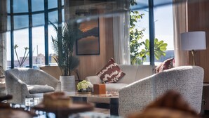 Una sala de estar moderna con un sofá, sillones, una mesa de centro y un ventanal con vistas.