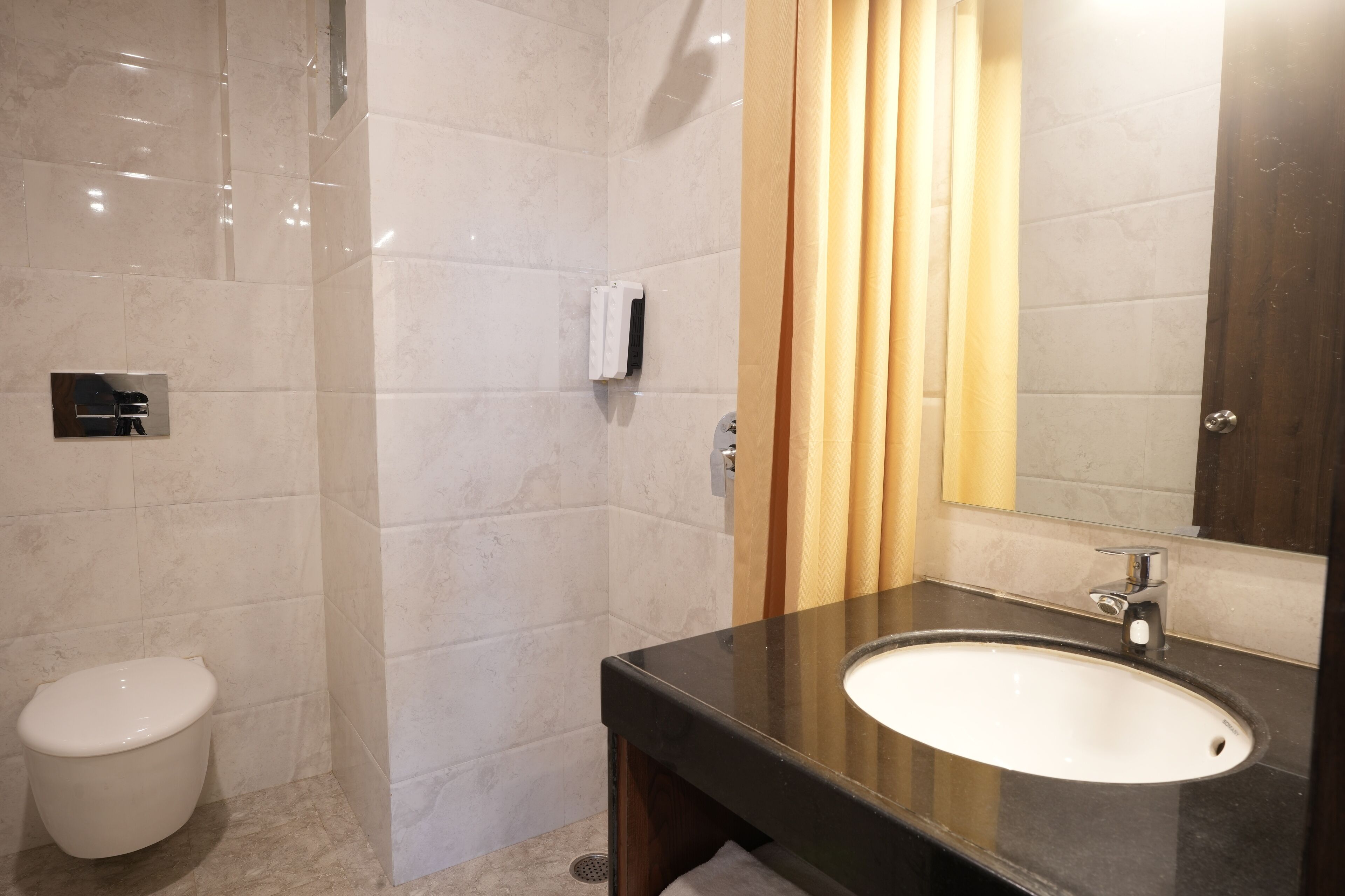 Ein modernes Badezimmer mit Toilette, Waschbecken und Duschbereich.