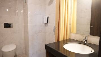 Ein modernes Badezimmer mit Toilette, Waschbecken und Duschbereich.