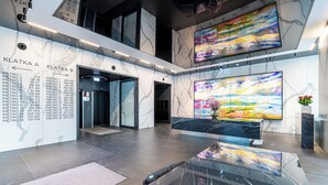 Eine moderne Lobby mit Marmorwänden, einem Verzeichnis und großen abstrakten Gemälden.