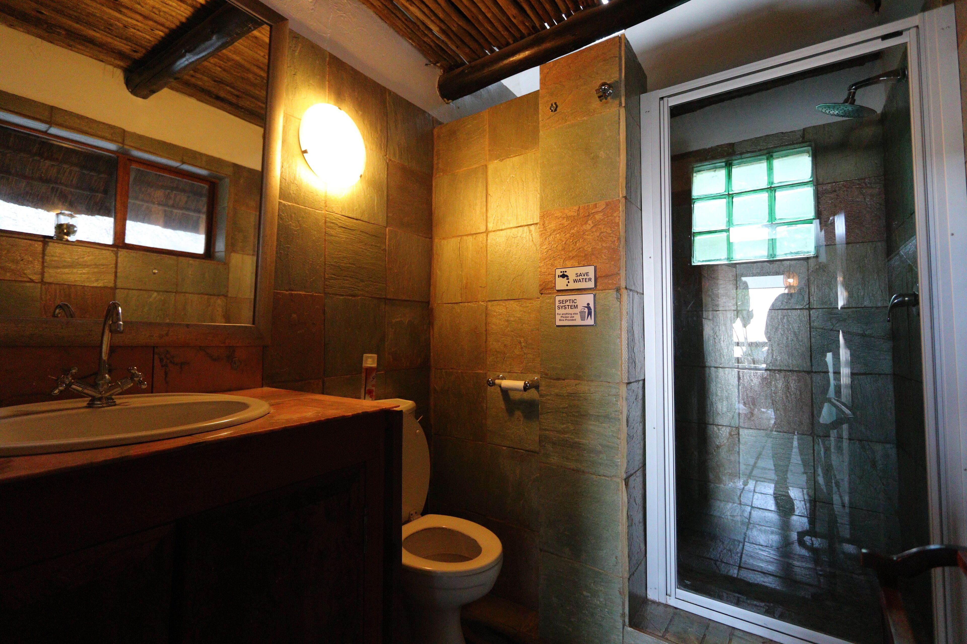 A bathroom with a sink, toilet, and shower area.
