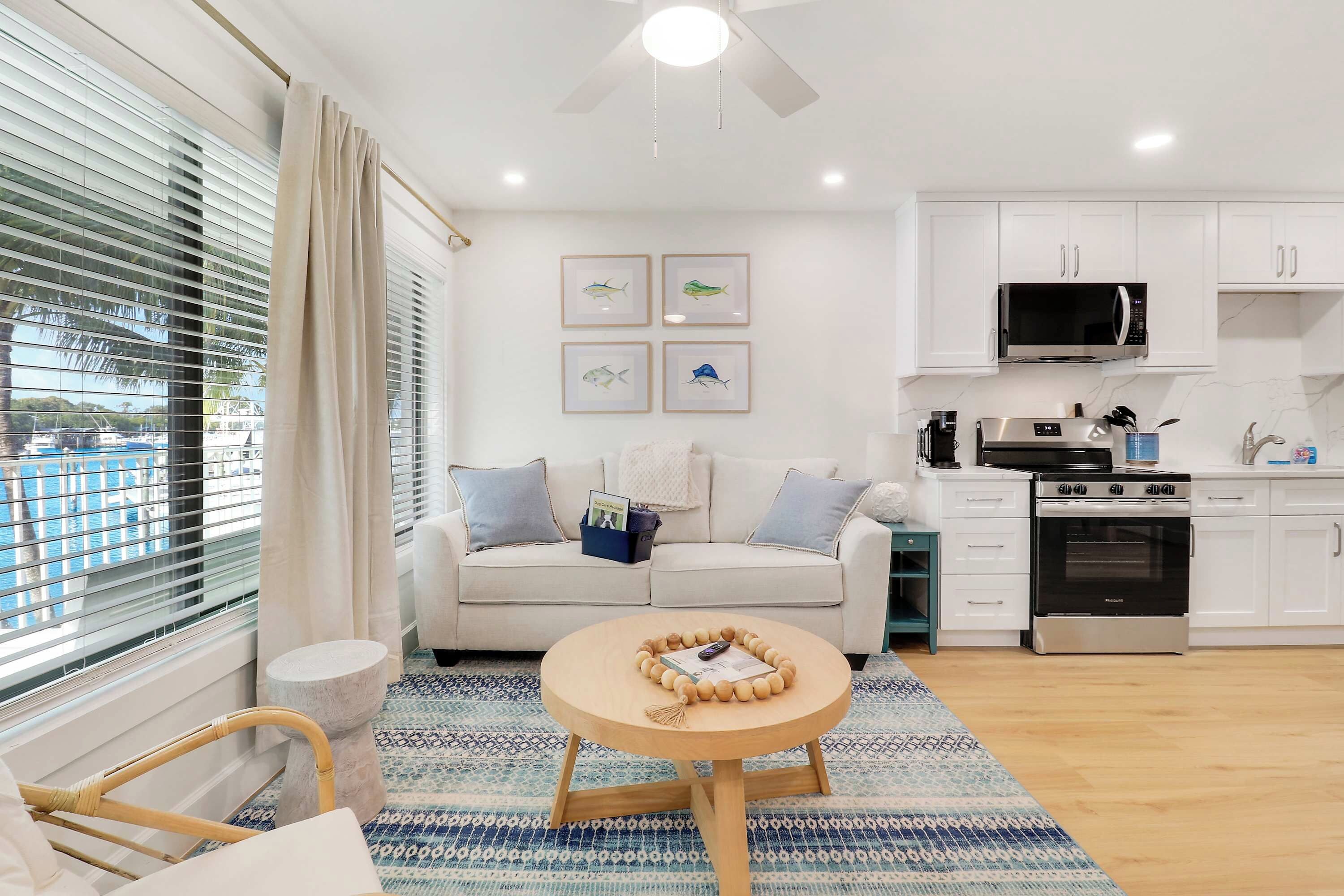 A modern living room with a sofa, a coffee table, and a kitchen area with a microwave and stove.