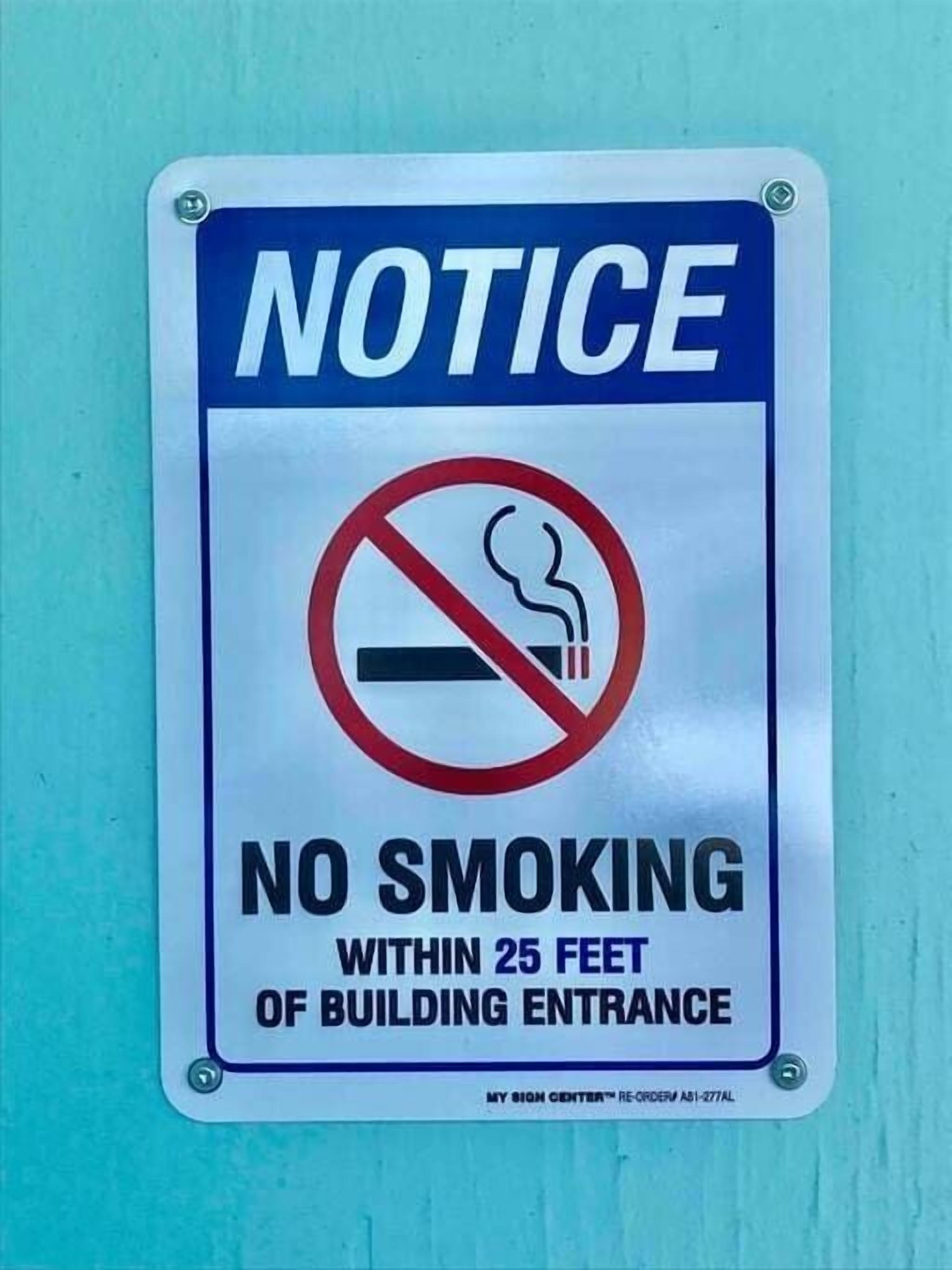 A notice sign indicating no smoking within 25 feet of the building entrance.