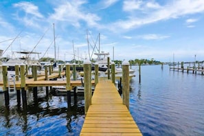 A wooden dock leading to a marina with boats docked. - Sailfish Suites - 12 - waterfront lodging (Stuart)