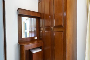 Een houten garderobe met spiegel en plank.