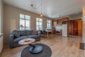 A modern apartment with a living room, dining area, and kitchen. - Day Dream Strandgata 11 (Akureyri)