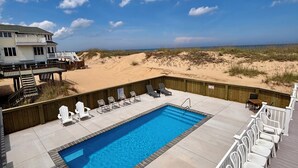 Una piscina con vista a la playa y las dunas.