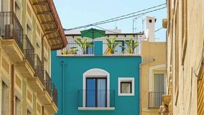A narrow street with buildings on either side, featuring balconies and a small door at the front of the central building. - Apt Charme Exceptionnel Alicante (Alacant)