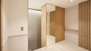 Un intérieur moderne avec une cloison en lattes de bois, un mur miroir et un plancher de couleur claire.