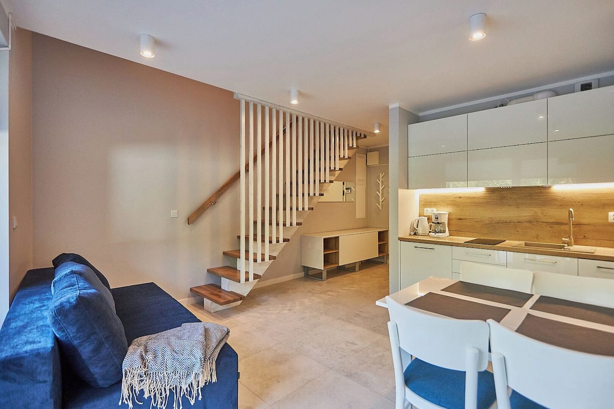 Ein zeitgemäßer Wohnraum mit Treppe, Essbereich und Küche.