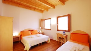 A bedroom with two beds, wooden flooring, and a desk with a chair. - Corte all'Olmo (Verona)