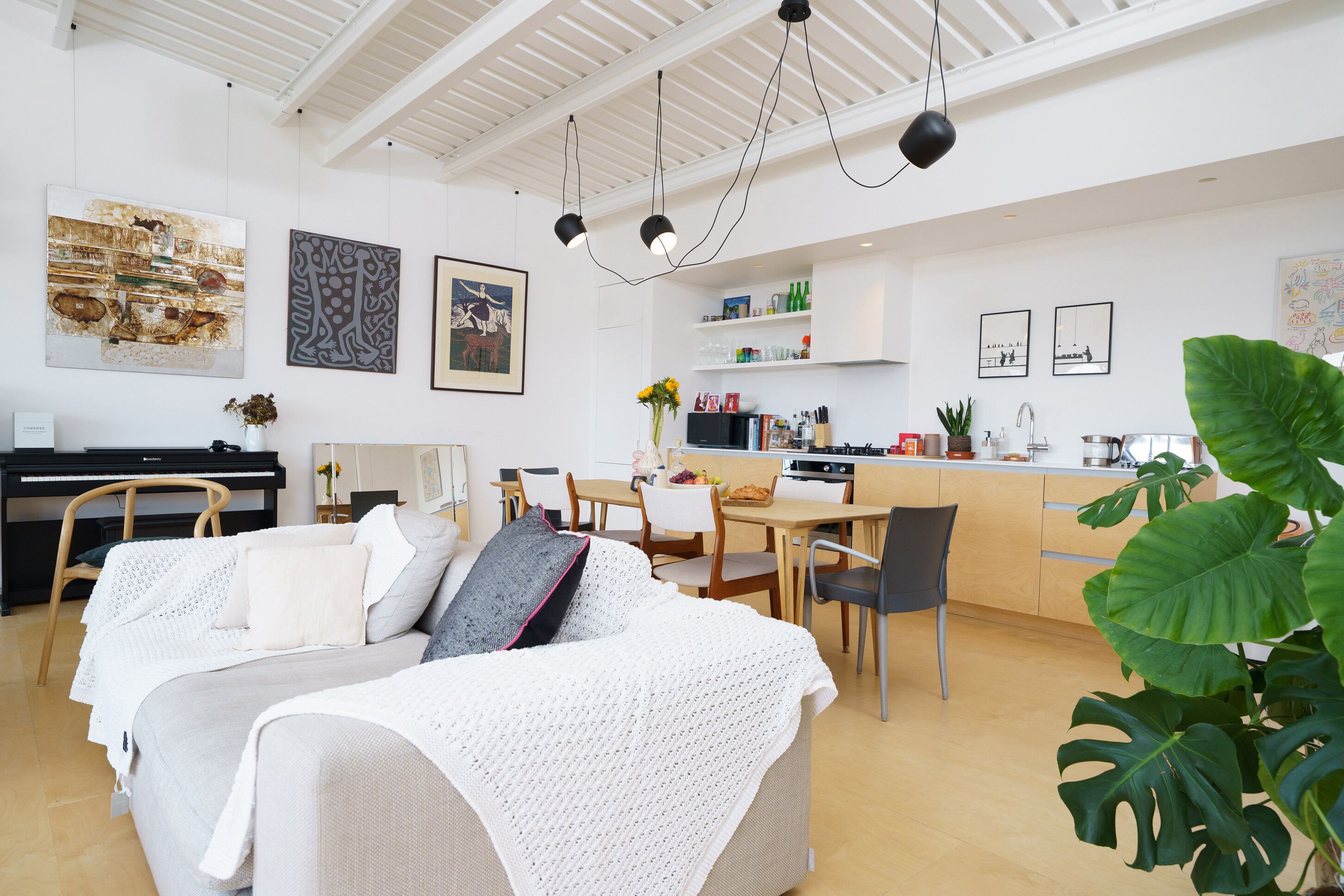 Un espace de vie moderne comprenant un canapé, une table à manger et un coin cuisine.