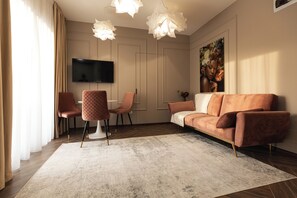 Departamento Deluxe, balcón | Área de sala de estar | Televisión de pantalla plana 