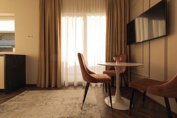 Apartamento Deluxe, balcón | Zona de estar | Una televisión de pantalla plana