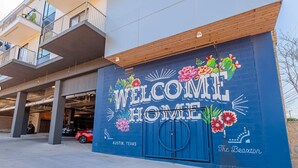 A building with a large mural saying "WELCOME HOME" and "Austin, Texas" on the side. - Landing | Spectacular 1BD, Courtyard, Gym (Austin)
