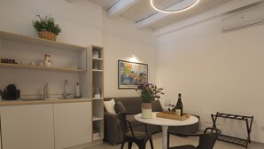 Una cocina moderna con comedor, que incluye una mesa redonda, sillas y una pequeña barra.