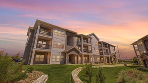 A multi-story residential building with balconies and a well-maintained lawn. - Landing | Chic 1BD, Clubhouse, Gym (Austin)