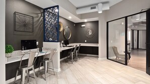 A modern office space with a long desk, multiple chairs, and a decorative wall panel. - Landing | Modern 1BD, Courtyard, Pool (Chesterfield)