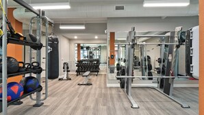 A gym with weightlifting equipment, exercise balls, and a punching bag. - Landing | Modern 1BD, Courtyard, Pool (Chesterfield)