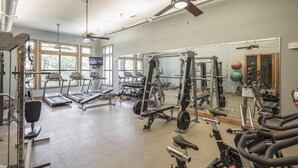 Een fitnessruimte met loopbanden, krachtapparaten en losse gewichten.