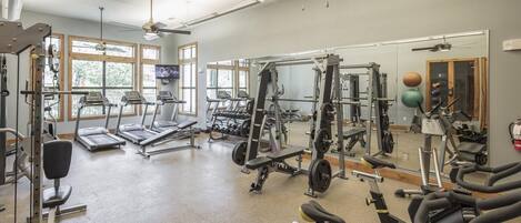 A gym with treadmills, weight machines, and free weights.