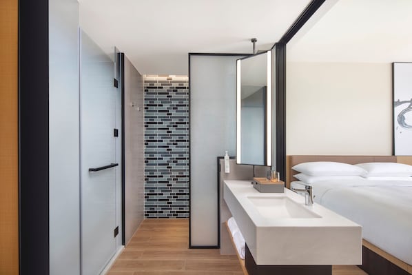 A modern hotel bathroom with a large mirror, a white sink, and a tiled backsplash. - Fairfield BY Marriott Shenzhen Dameisha (Shenzhen)