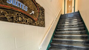 A staircase leading to a room labeled 'Suites' with a decorative sign above it. - Downtown Friday Harbor! Newly Built! PM (Friday Harbor)
