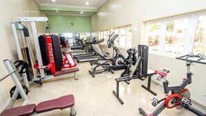A gym with various exercise equipment, including treadmills, weight machines, and a bench. - Aaron's Place (Enugu)