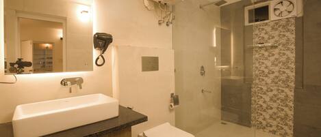 A modern bathroom with a large sink, toilet, and glass shower enclosure.