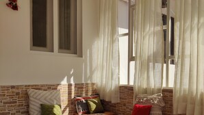 Una habitación acogedora con pared de ladrillo, un banco de madera y una alfombra roja.