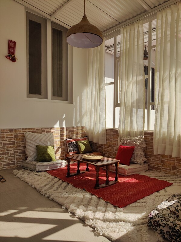 Une pièce chaleureuse avec un mur en briques, un banc en bois et un tapis rouge.