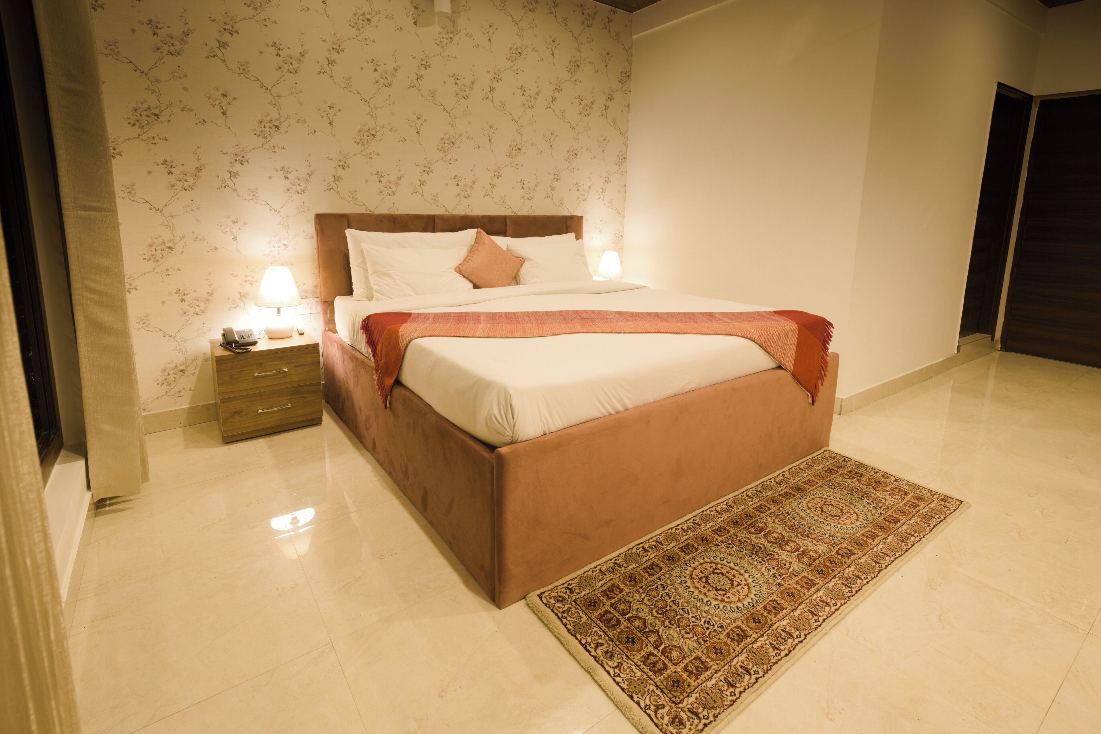 A bedroom with a bed, nightstands, and a rug.