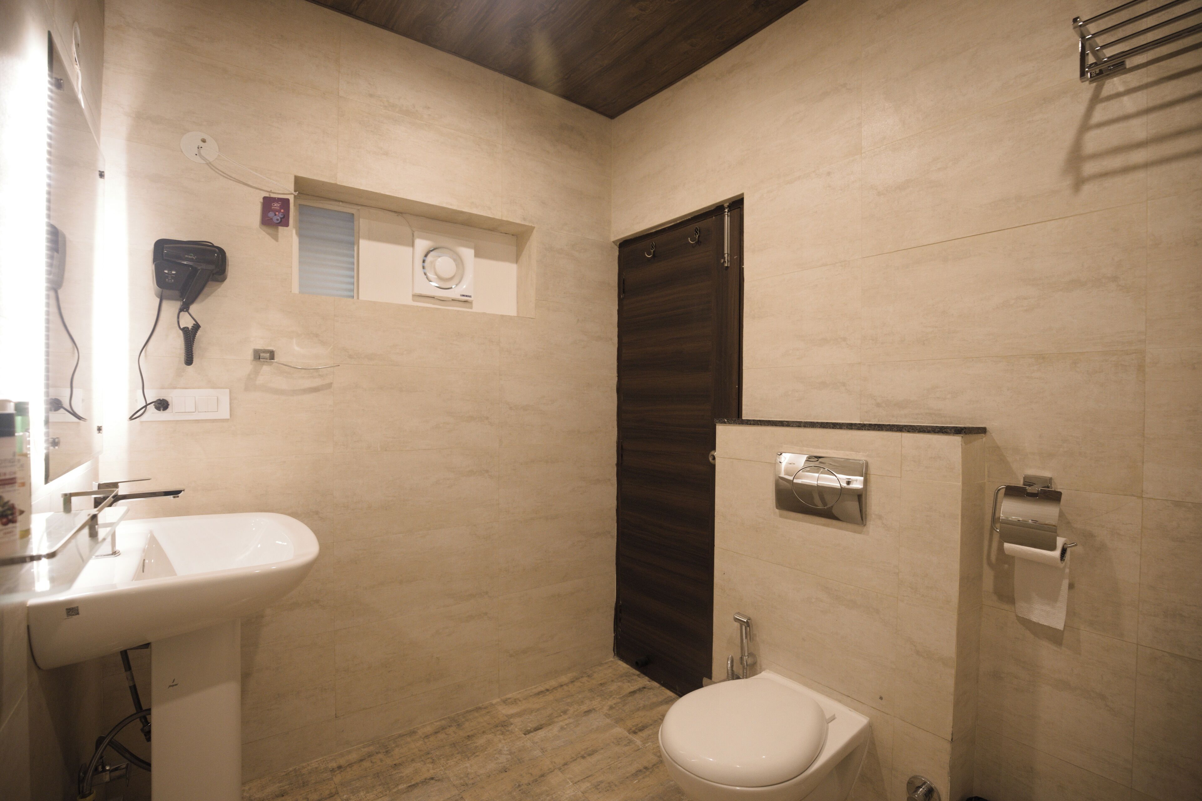 Un baño con lavabo, inodoro y toallero.