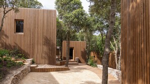 A modern wooden building with a stone pathway leading to a wooden deck. - Ecolodge Residence Sophia (Bonifacio)