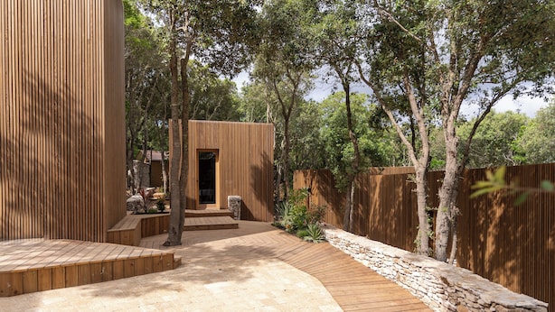 A wooden deck with a stone pathway leading to a small wooden structure. - Ecolodge Residence Sophia (Bonifacio)
