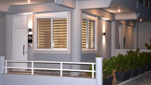 Een modern gebouw met grote ramen, een witte balustrade en potplanten.