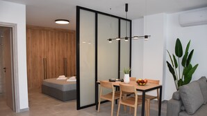 Een moderne kamer met een eettafel, stoelen, een potplant en een bank.