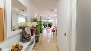 Un couloir agrémenté d’un miroir, d’objets décoratifs et offrant un aperçu d’une salle à manger.