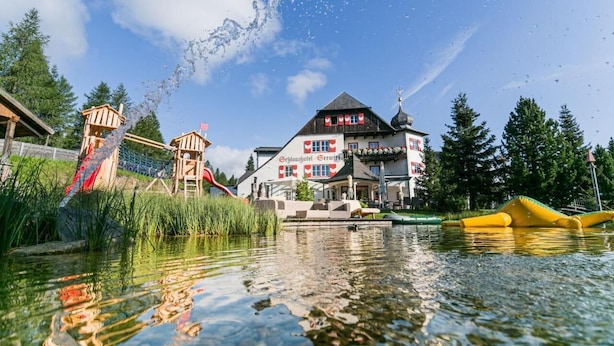 A hotel with a traditional European architectural style, featuring a prominent building with a sloped roof and a red and white facade. - Schlosshotel Seewirt (Stadl-Predlitz)