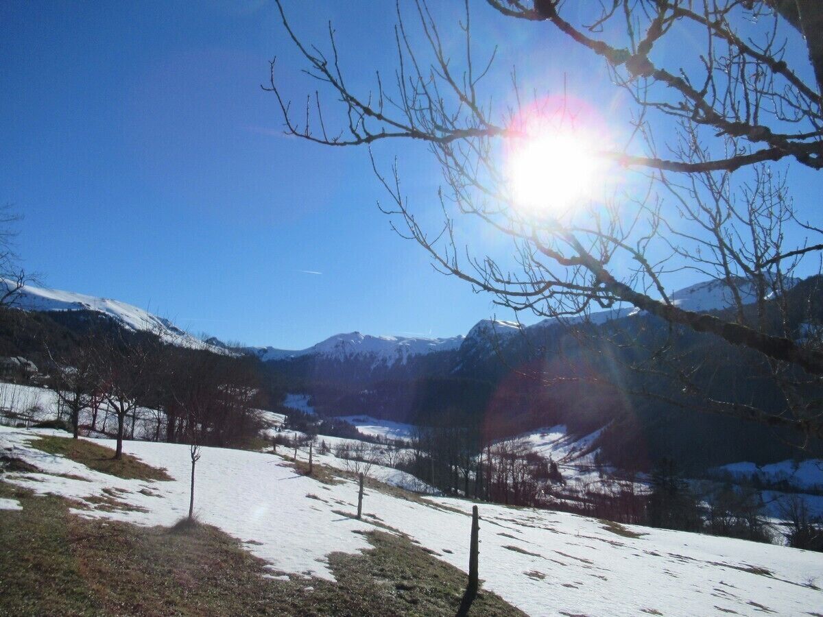A snowy landscape with mountains in the background and a clear sky.