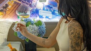 A person sitting at a table with a bottle of champagne, a vase of flowers, and a cityscape view in the background. - Hotel Ristorante Valamerica (Sernio)
