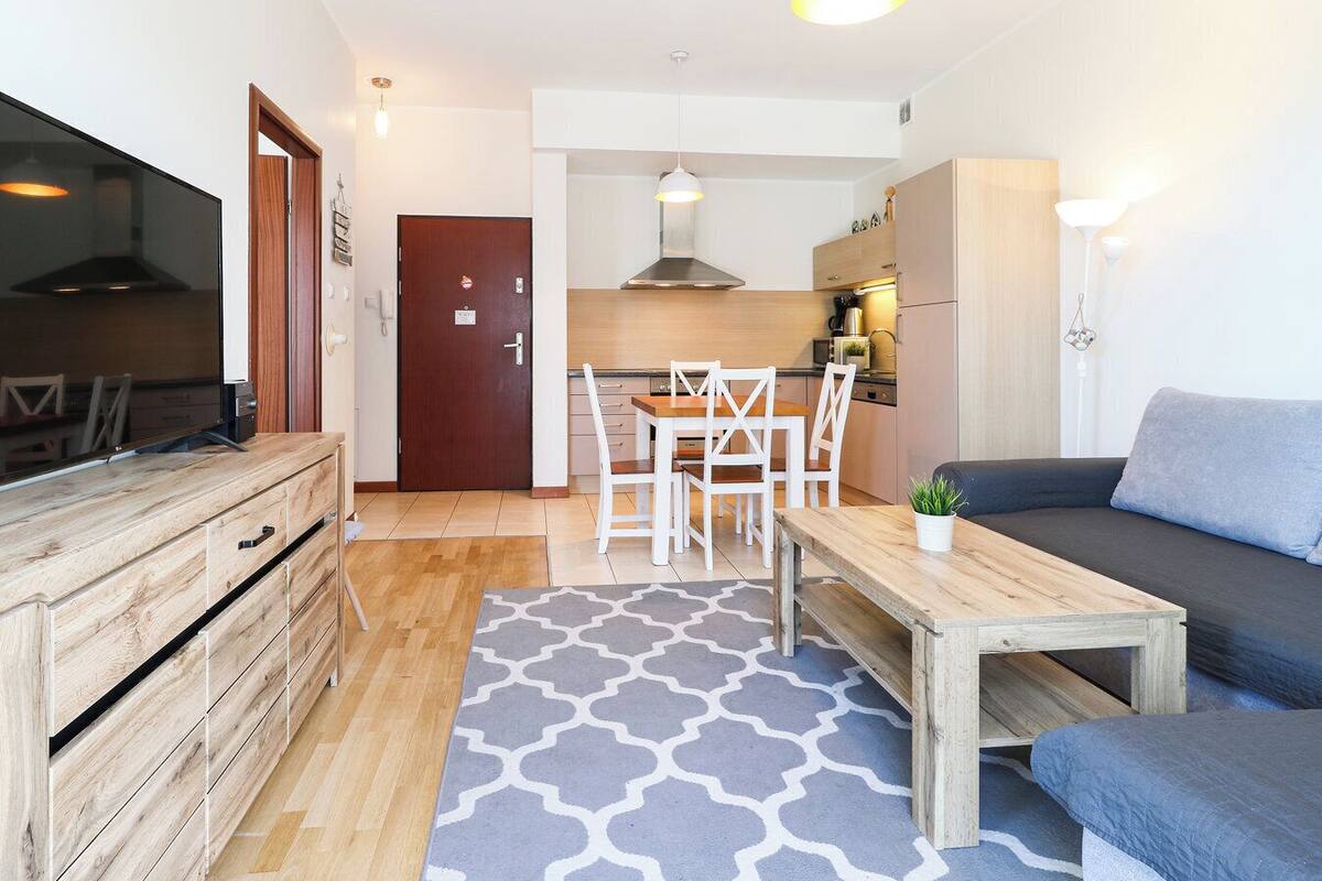 A modern apartment with a living room, dining area, and kitchen.