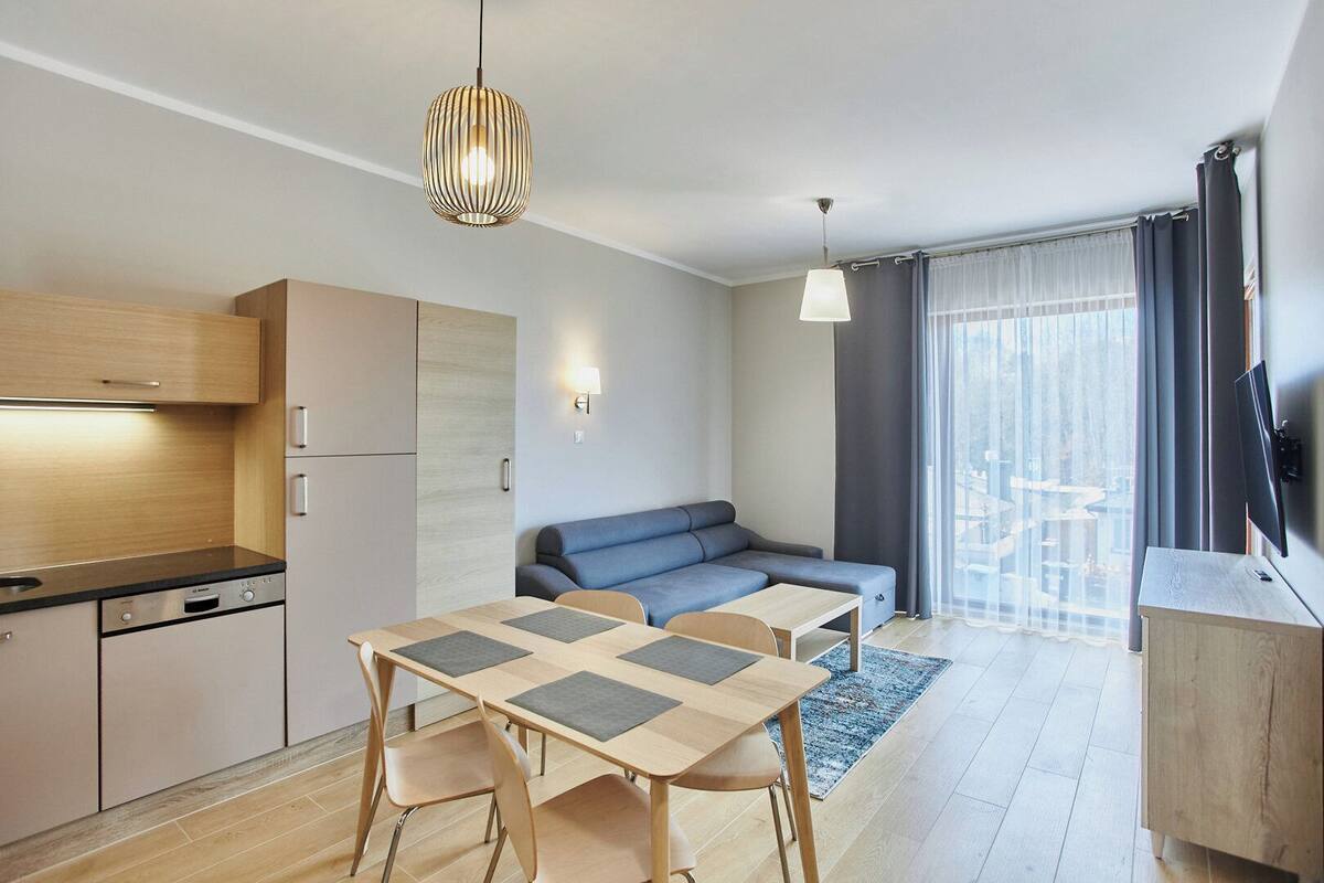 A modern apartment with a kitchen, dining area, and living room.
