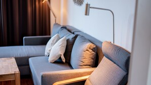 A modern living room with a grey sofa, a wooden coffee table, and a floor lamp.