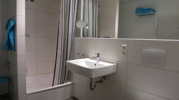 A modern bathroom with a bathtub, a sink, and a toilet.