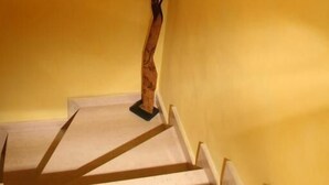 Eine Treppe mit hölzernen Geländern und einer Wandleuchte.
