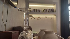 A room with a glass vase, a wooden side table, and a shelf with decorative items. - Pyramids Kingdom  (Giza)