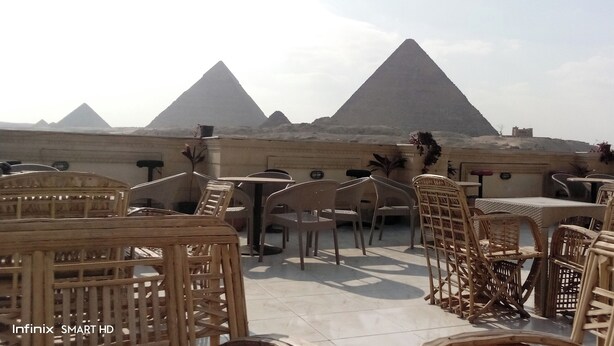 Outdoor seating with wicker furniture and a view of the pyramids. - Pyramids Kingdom  (Giza)