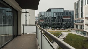 A modern building with a balcony, large windows, and a view of other buildings. - Nest Inn Magic Apartment Scala Center (Cluj-Napoca)