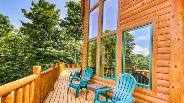 A wooden cabin with a deck, large windows, and outdoor seating. - *Lake/Mtn View*Hot Tub*Firepace*Game Room* (Greenville)